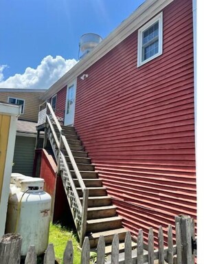 Stunning home with a charming porch and staircase leading to an upper level.