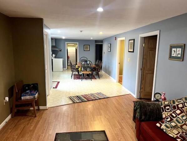 Relax in this inviting living area with a dining space, framed artwork, and a cozy table for two.
