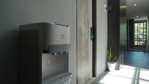 A water dispenser mounted on a wall in a hallway. - Dparagon Menteng (Jakarta)