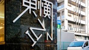 A building with a prominent sign featuring large, stylized letters. - Toyoko Inn Yokohama-Eki Nishi-Guchi (Yokohama)