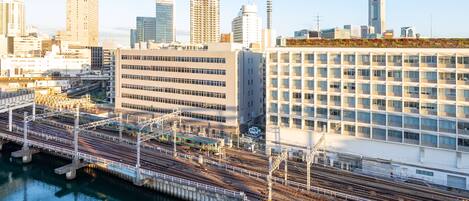 Un paisaje urbano con edificios modernos, una estación de tren y una masa de agua.