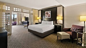 Ein Hotelzimmer mit einem großen Bett, einem Schreibtisch, einem Stuhl und einer Couch.