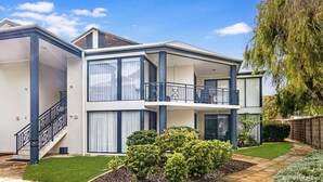 A modern two-story house with a balcony, a staircase, and a well-maintained garden. - Escape to the Cape - Villa 15 (Broadwater)