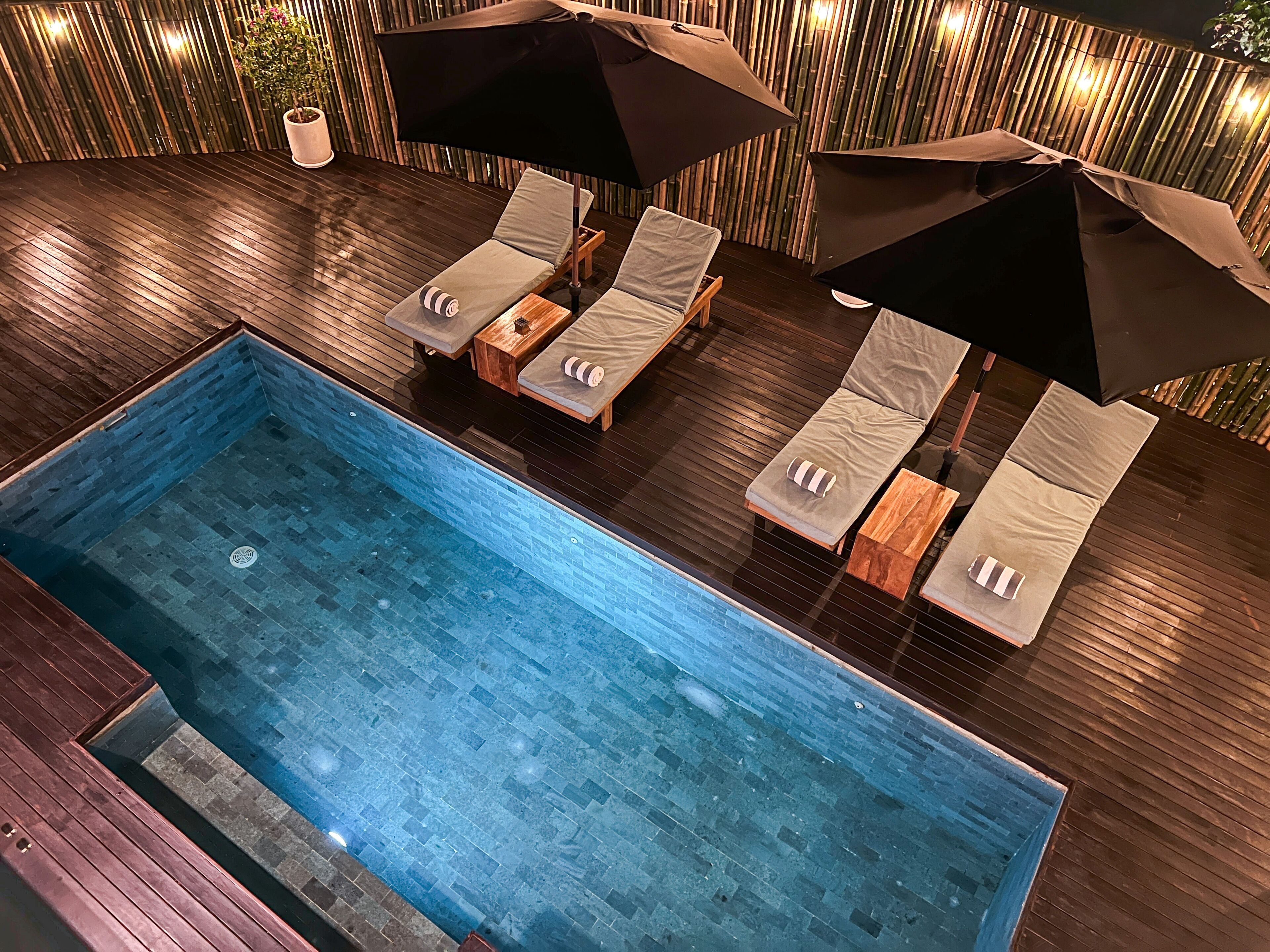 An indoor swimming pool with lounge chairs and umbrellas.