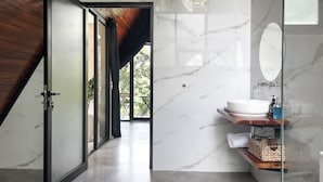 Une salle de bain moderne avec un mur en marbre, un plafond en bois et une cabine de douche en verre.
