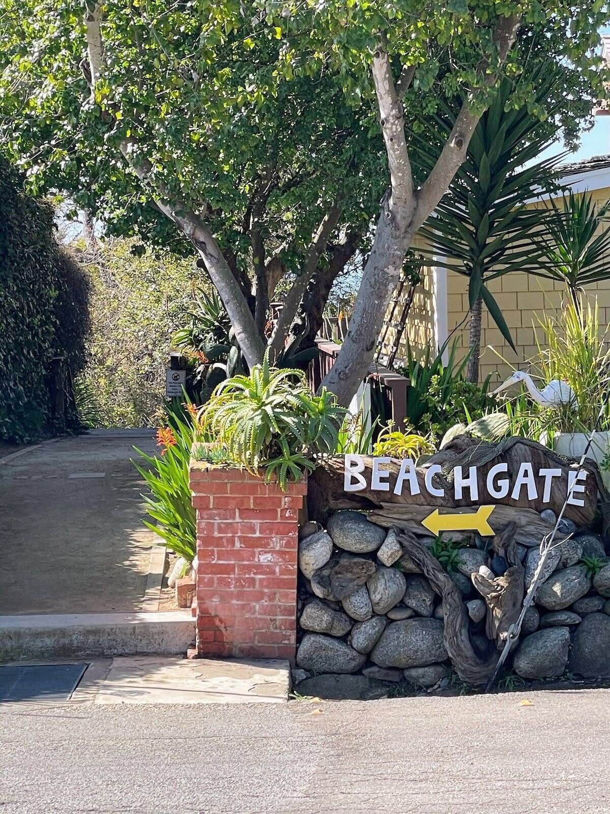 Et skilt med navnet 'BEACHGATE' og en pil, der peger mod højre, der viser vejen til stranden.