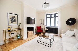 Relax in this stylish living room with a sofa, coffee table, armchair, and fireplace.