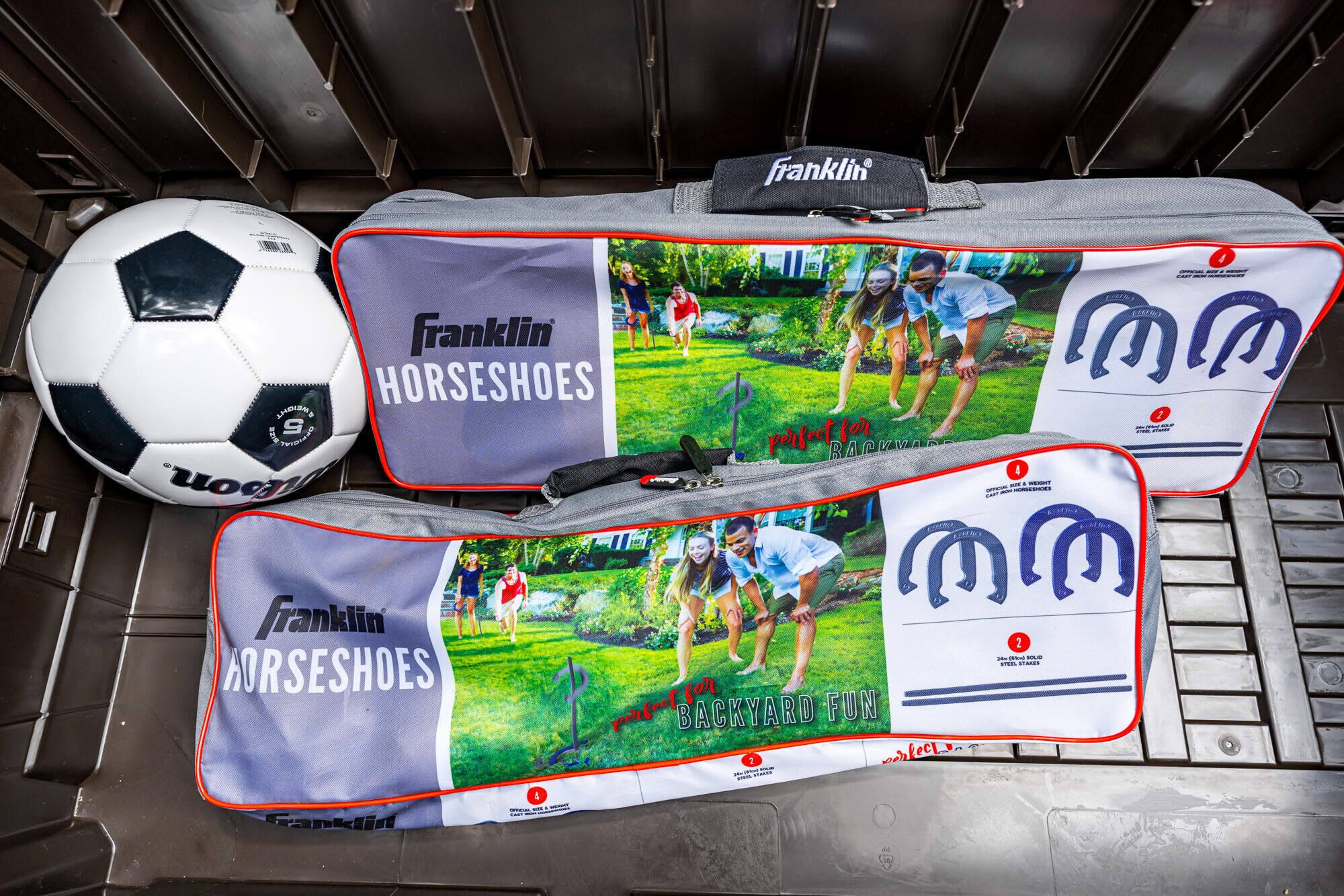 A storage area with a soccer ball and two Franklin Horseshoes bags.