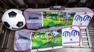 A storage area with a soccer ball and two Franklin Horseshoes bags.