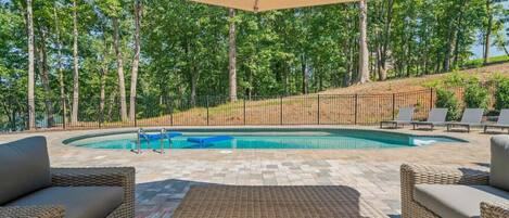 A pool area with wicker furniture and a canopy.