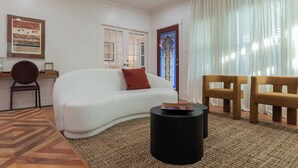A living room with a white sofa, a round black coffee table, and two wooden chairs. - 💎 The Ares A Luxury! 💎 Montrose Bunker! 5BR ⭐️⭐️⭐️⭐️⭐️  (Houston)
