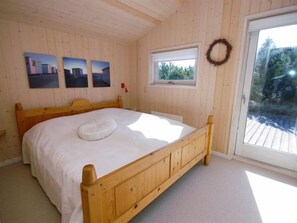 Relax in this serene bedroom with a comfortable bed, large window, and peaceful views of the surrounding greenery.