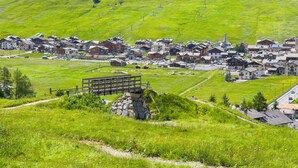 A village with traditional houses, a stone bridge, and a ski lift in the background. - Wood House Livigno Ski in - Ski out 10m (Livigno)