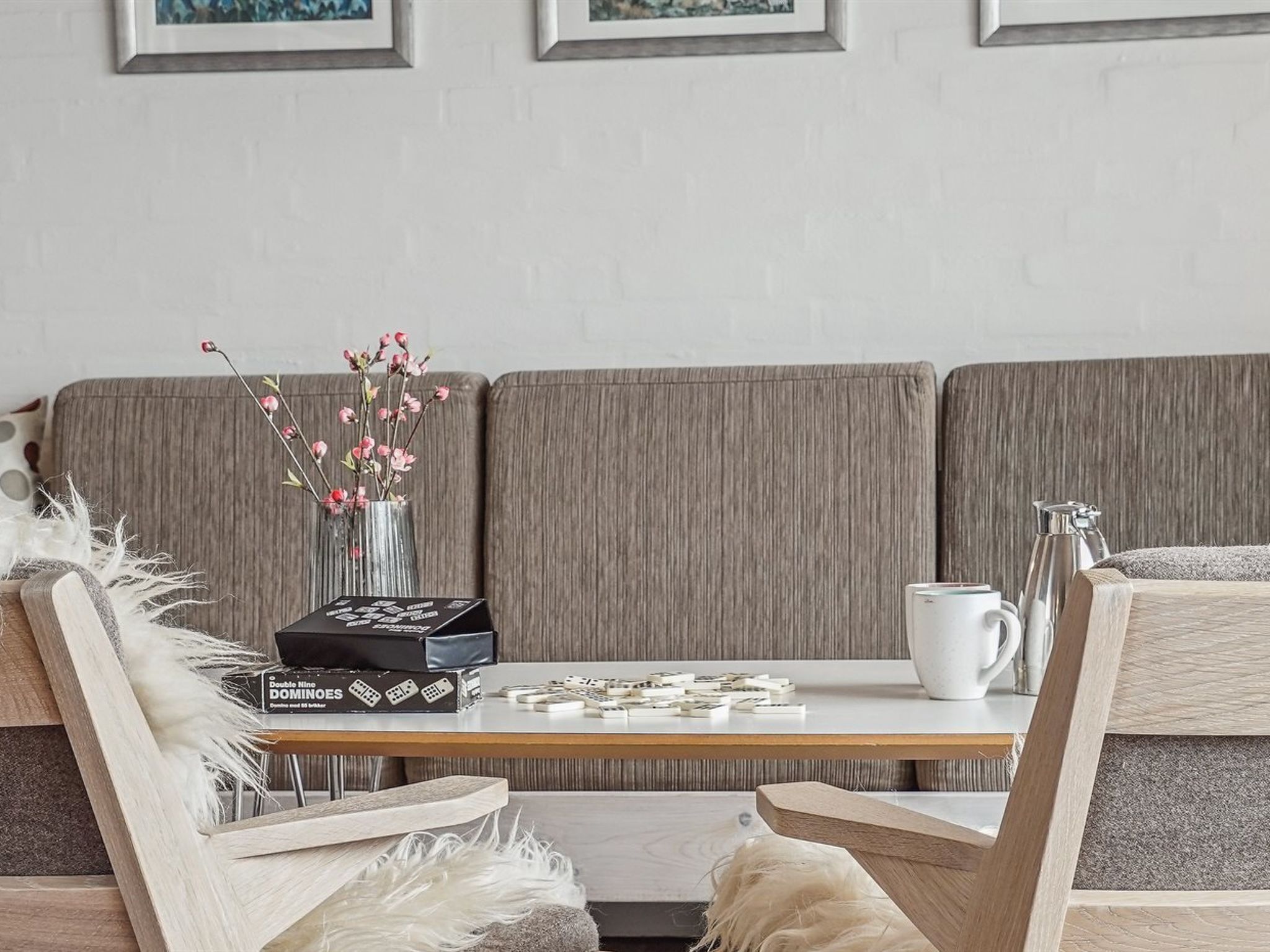 Un salon moderne avec un canapé gris, une table basse en bois et une tasse blanche.