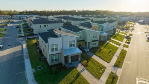 Un quartier résidentiel avec des maisons modernes, un parking et un ciel dégagé.