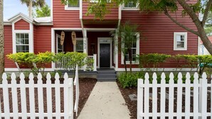 A red house with a white picket fence, a front porch, and a small garden. - Whitefish Lodge  Downtown Walk to Everything (St. Augustine)