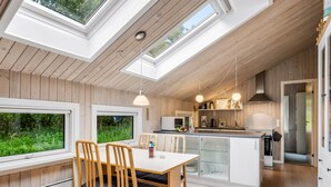 A modern kitchen with wooden cabinets, a central island, and pendant lighting.