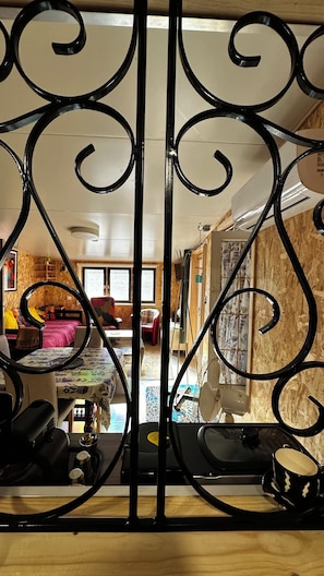 Una habitación con una cama, una silla, una mesa y un ventilador.