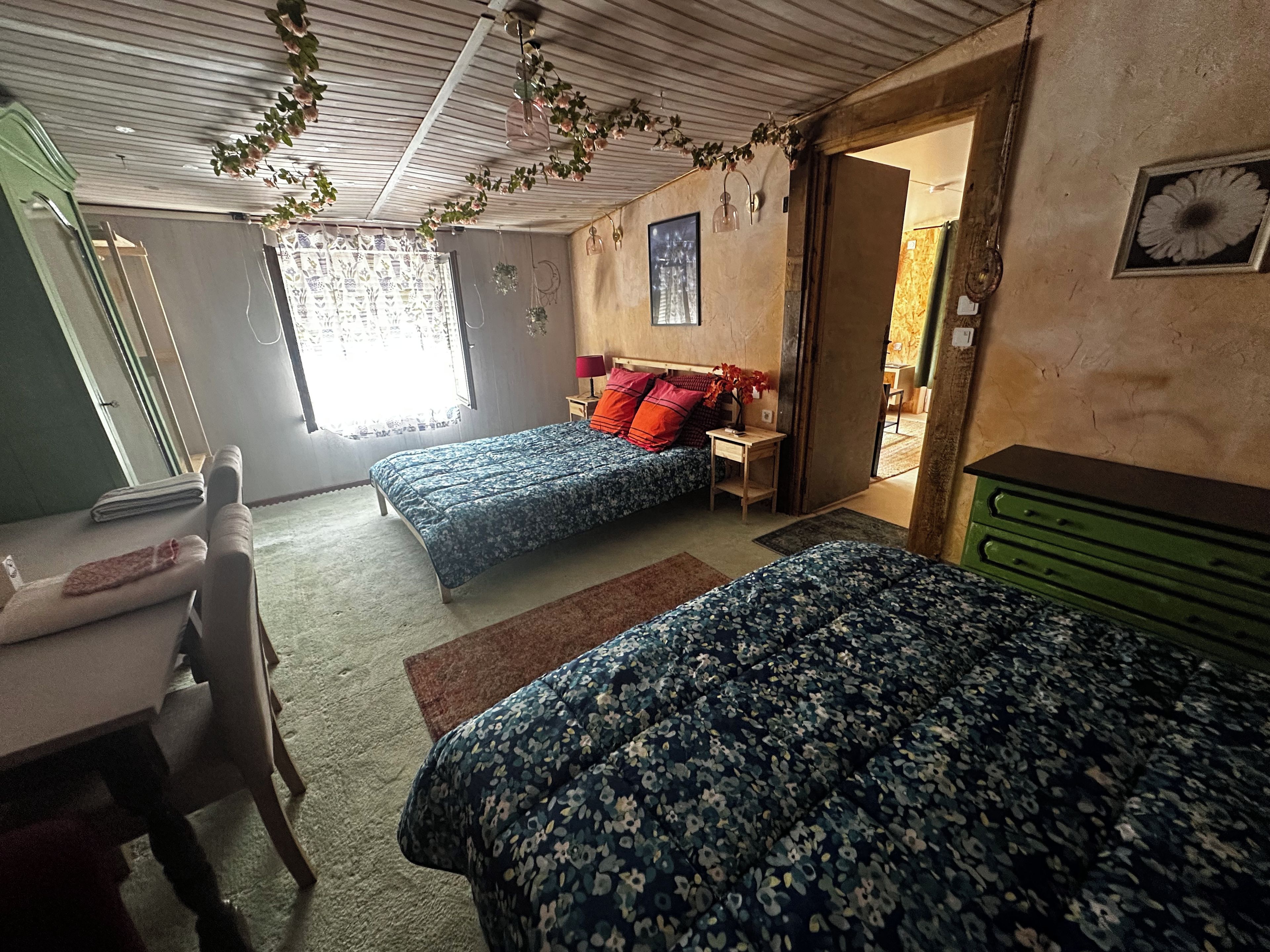Un dormitorio con dos camas, un escritorio y un aparador.