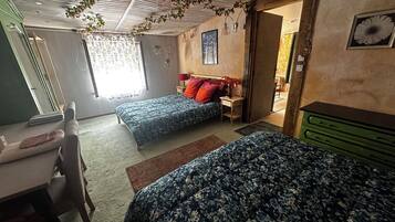 Un dormitorio con dos camas, un escritorio y un aparador.