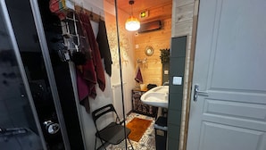 A bathroom with a sink, a mirror, a towel rack, and a patterned floor. - Chalet la Dryade JURA, waterfalls, lake, forests... (pets welcome) (Monnet La Ville)