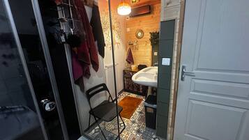 Een badkamer met een wastafel, een spiegel, een handdoekhouder en een vloer met een patroon.