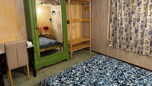 A room with a bed, a green wardrobe, a wooden bunk bed, a desk with a chair, and a patterned curtain. - Chalet la Dryade JURA, waterfalls, lake, forests... (pets welcome) (Monnet La Ville)