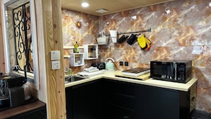 A compact kitchen with a microwave, kettle, and a coffee maker. - Chalet la Dryade JURA, waterfalls, lake, forests... (pets welcome) (Monnet La Ville)