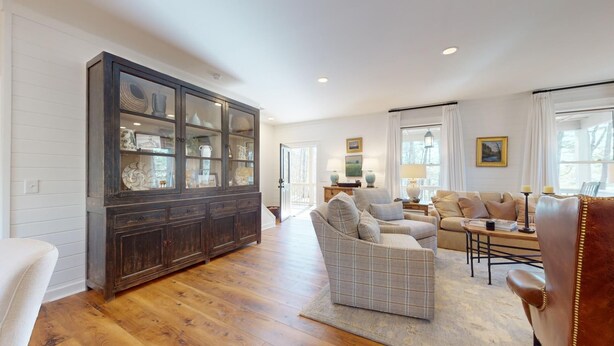 A spacious living room with a large wooden cabinet, a plaid sofa, and a leather armchair. - Lake Views, a Pool Table, and a Porch Swing. The Perfect Mountain Trip | Lakeview Hideaway (Highlands)