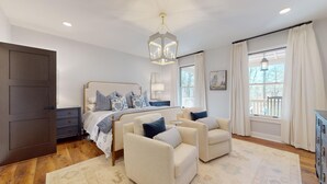A bedroom with a bed, two armchairs, a nightstand, a dresser, and a window with curtains. - Lake Views, a Pool Table, and a Porch Swing. The Perfect Mountain Trip | Lakeview Hideaway (Highlands)