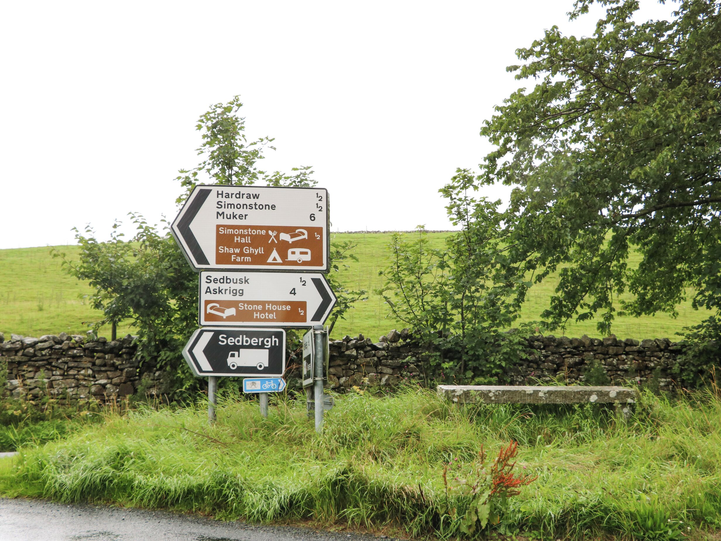 A directional sign with multiple destinations and distances.