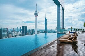 An infinity pool with a city skyline view, including a tower and modern buildings. - Happy Suite at Platinum KLCC (Kuala Lumpur)