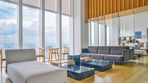 Un salón espacioso con un amplio ventanal, un sofá, una mesa de centro y una estantería.