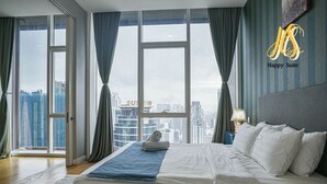 Una habitación de hotel con una cama grande, vistas de la ciudad y un logotipo en la esquina.