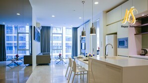 Una suite de hotel moderna con una amplia sala de estar, un comedor y una kitchenette.