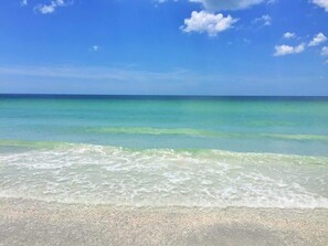 A beach with clear turquoise water and a sandy shore.