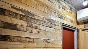 A room with a wooden wall and a red door.