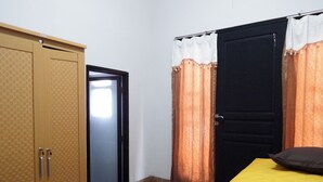 Ein Zimmer mit einem Bett, einem Kleiderschrank und einer Tür.