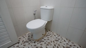 Un inodoro en un baño con piso de estampado geométrico.