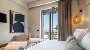 Ein Schlafzimmer mit einem großen Bett, Blick ins Freie, einem Gemälde an der Wand und einer Lampe.