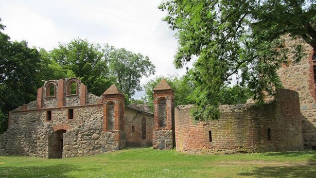 An old stone building with arched windows and a tower.