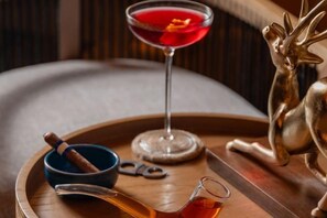 A tray with a martini glass, a small bowl with a cinnamon stick, a pair of scissors, and a bottle of whiskey. - Coorg Marriott Resort & Spa (Kandanakolli)