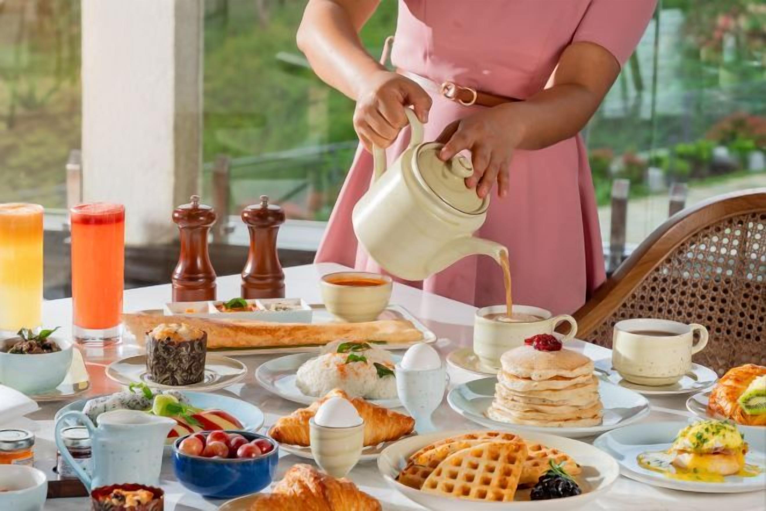 A breakfast setting with a variety of food items and beverages on a table.