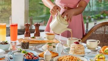 A breakfast setting with a variety of food items and beverages on a table.