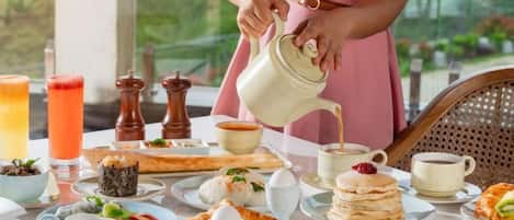 A breakfast setting with a variety of food items and beverages on a table.