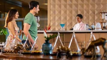 A bar area with a counter, bar stools, and a bartender.