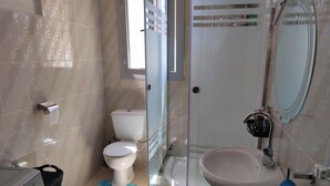 A bathroom with a toilet, a glass shower enclosure, a sink, and a blue bath mat. - Chalet Stella Makadi Beach 5 Stars (Makadi Bay)