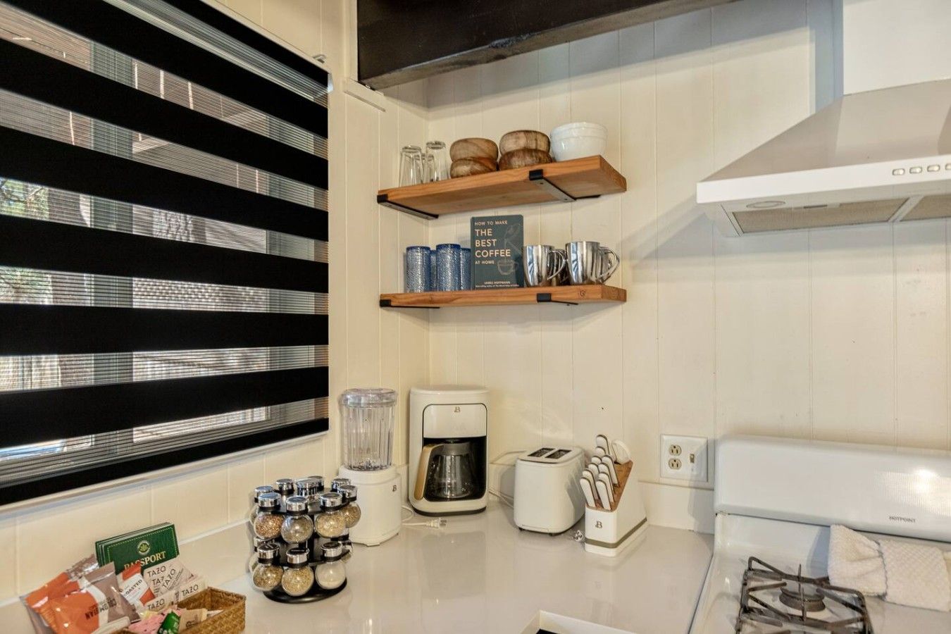 A kitchen with a coffee maker, toaster, and spice rack.