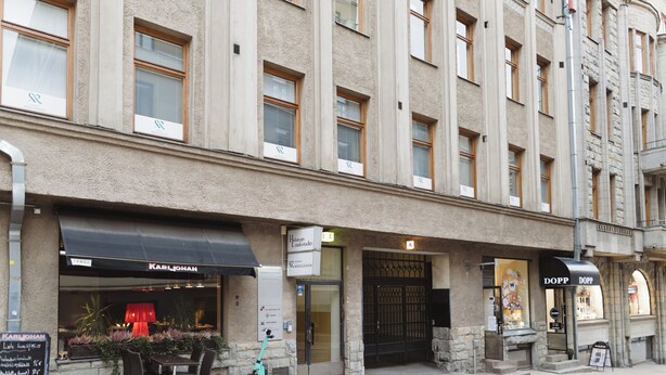 A building with multiple storefronts, including a restaurant named "Karljohan" and a shop named "Dopp." - Hotel Bastian  (Helsinki)