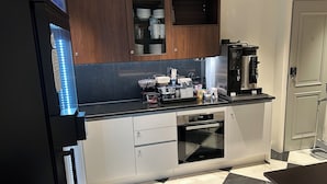 A modern kitchen with a black and white checkered floor, stainless steel appliances, and wooden cabinets. - Hotel Bastian  (Helsinki)